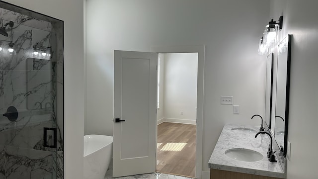 bathroom with a sink, a marble finish shower, and a freestanding tub