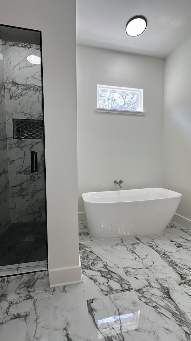 bathroom featuring a soaking tub, marble finish floor, and a marble finish shower