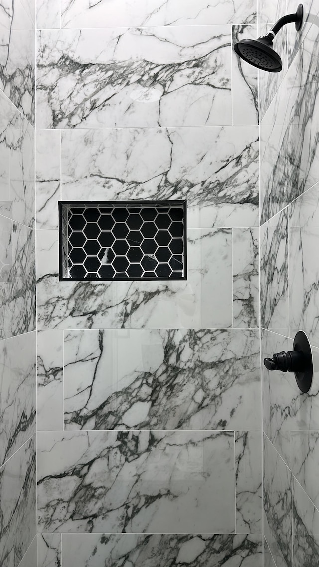 room details featuring a marble finish shower