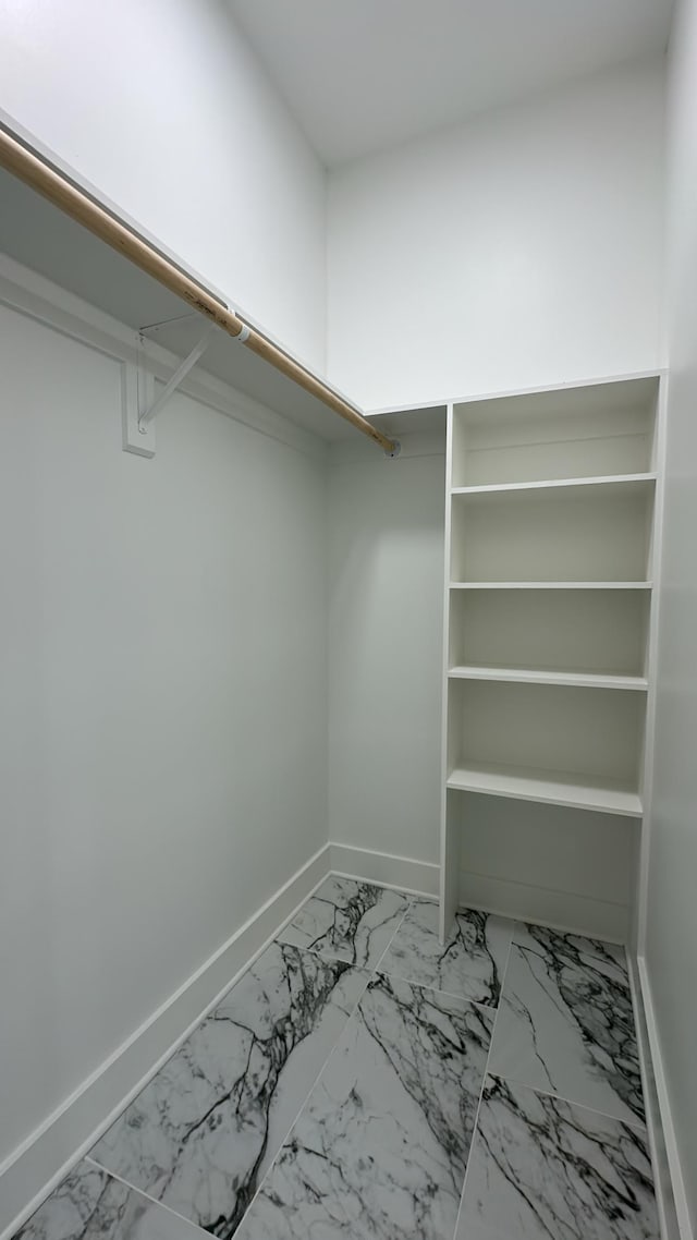 walk in closet with marble finish floor