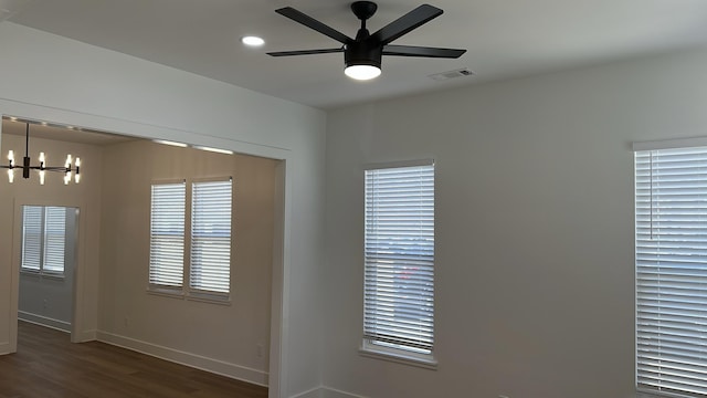 unfurnished room with visible vents, ceiling fan with notable chandelier, wood finished floors, recessed lighting, and baseboards