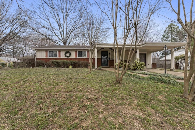 ranch-style house featuring a carport, a front yard, brick siding, and fence