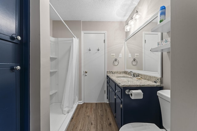 full bathroom with a shower with curtain, toilet, a textured ceiling, wood finished floors, and vanity