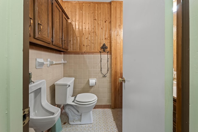 half bathroom with tile walls, toilet, and tile patterned floors