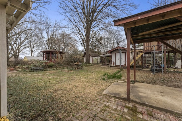 view of yard featuring stairs, an outbuilding, a patio area, and a shed