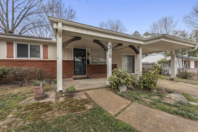 exterior space with brick siding, covered porch, and board and batten siding