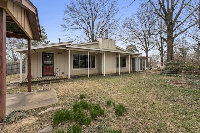 rear view of house with a yard and fence