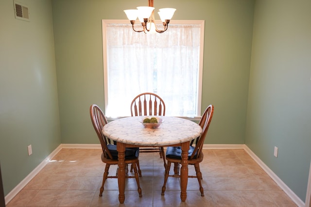 dining space with visible vents, baseboards, a chandelier, and light tile patterned flooring