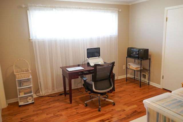 office area featuring ornamental molding, baseboards, and wood finished floors