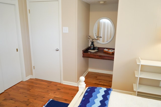 bedroom featuring wood finished floors and baseboards