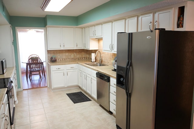 kitchen featuring a sink, tasteful backsplash, appliances with stainless steel finishes, and light countertops