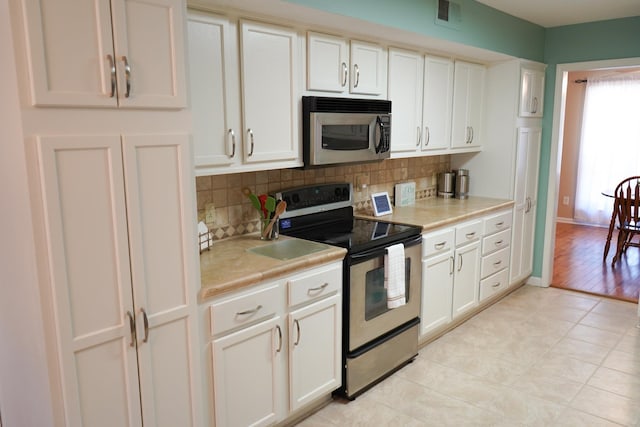 kitchen with visible vents, stainless steel appliances, light countertops, white cabinets, and tasteful backsplash