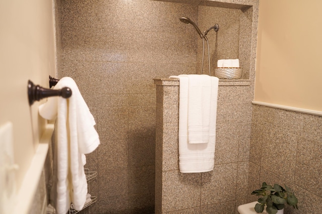 interior details featuring wainscoting and a tile shower