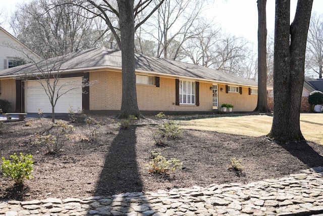 ranch-style home featuring a garage and brick siding