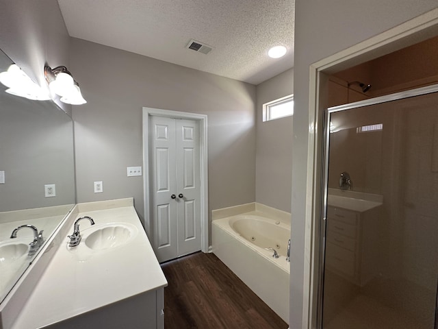 full bathroom with visible vents, a stall shower, a sink, a textured ceiling, and a whirlpool tub