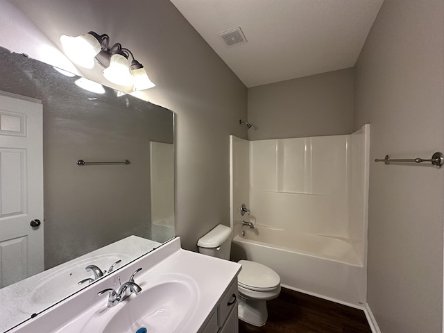 full bathroom featuring visible vents, shower / washtub combination, toilet, wood finished floors, and vanity