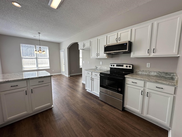 kitchen featuring white cabinets, arched walkways, and appliances with stainless steel finishes