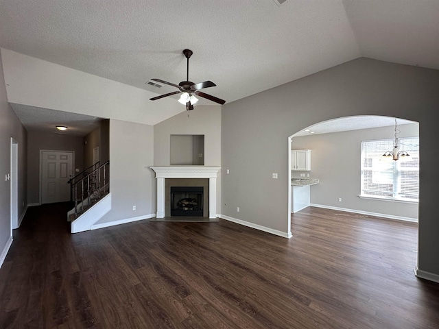 unfurnished living room with stairway, lofted ceiling, visible vents, and ceiling fan with notable chandelier