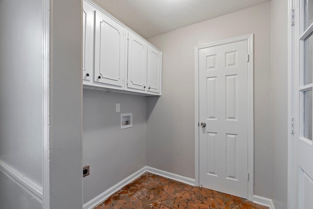 laundry room with baseboards, hookup for a washing machine, cabinet space, electric dryer hookup, and a textured ceiling