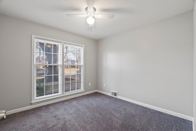 spare room featuring visible vents, a textured ceiling, carpet flooring, baseboards, and ceiling fan