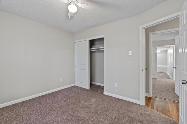 unfurnished bedroom with a closet, carpet flooring, a textured ceiling, and baseboards