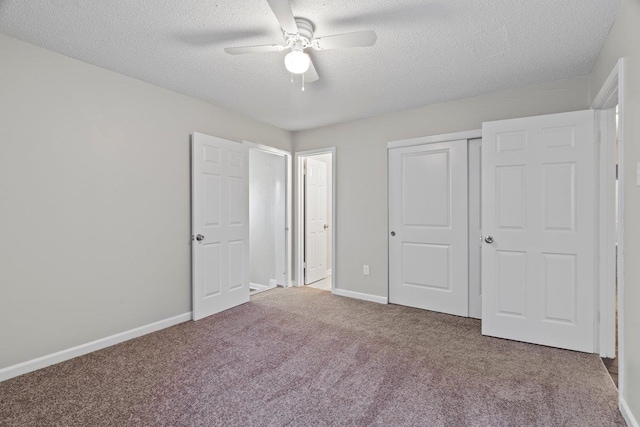 unfurnished bedroom with a textured ceiling, a closet, carpet flooring, baseboards, and ceiling fan