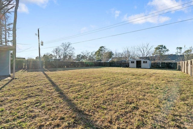 view of yard with an outbuilding, a storage shed, and a fenced backyard