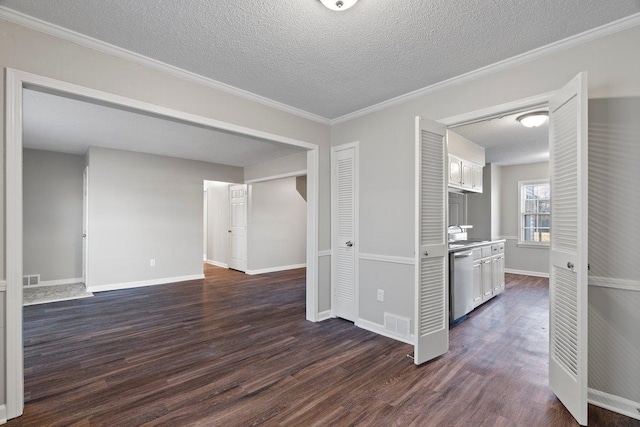 spare room with baseboards, visible vents, dark wood finished floors, a sink, and a textured ceiling