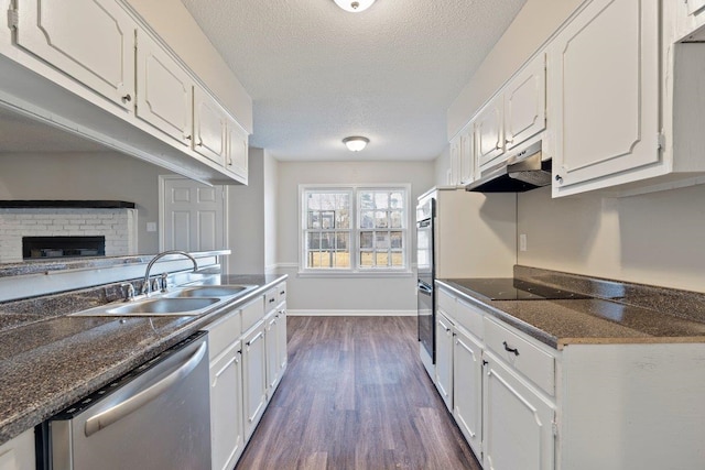 kitchen featuring under cabinet range hood, white cabinetry, black appliances, and a sink