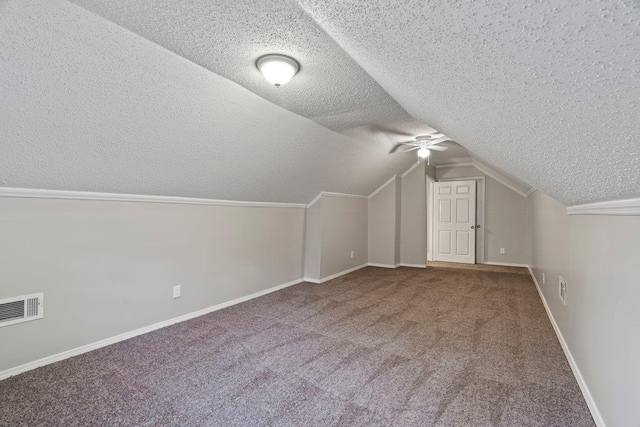 bonus room with visible vents, vaulted ceiling, carpet floors, a textured ceiling, and a ceiling fan