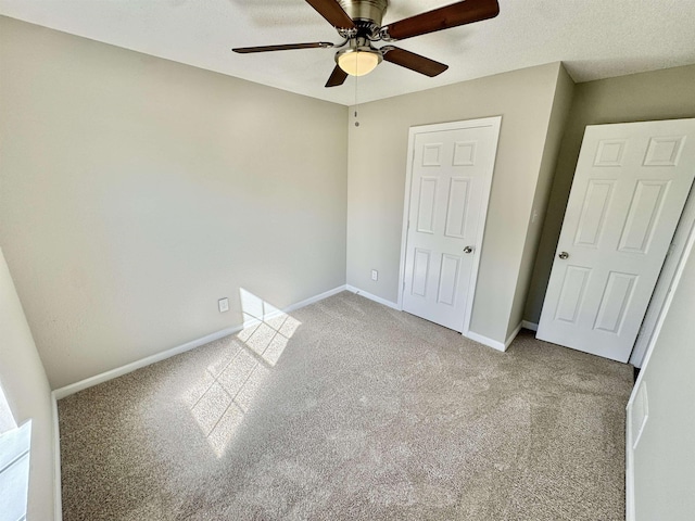 unfurnished bedroom with baseboards, light colored carpet, and a ceiling fan