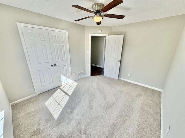 unfurnished bedroom featuring carpet, visible vents, a closet, and baseboards