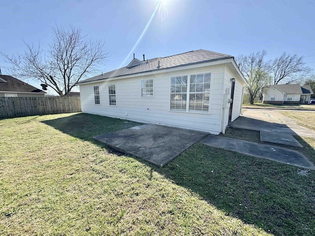 back of property featuring a patio, a yard, and fence