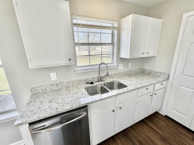 kitchen with dark wood finished floors, dishwasher, light stone counters, white cabinets, and a sink