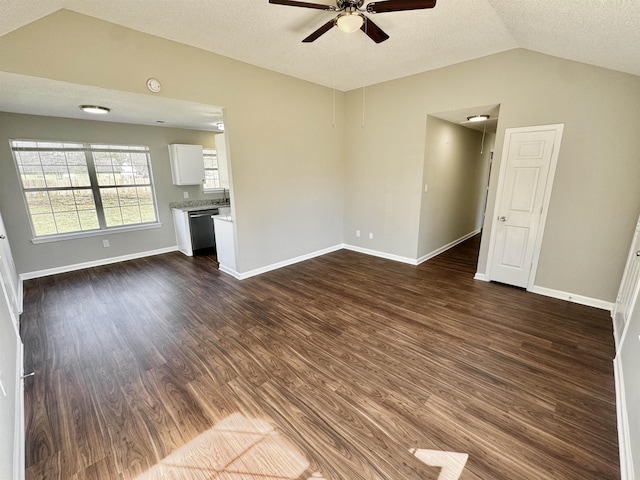 unfurnished living room featuring a ceiling fan, baseboards, dark wood finished floors, lofted ceiling, and a textured ceiling