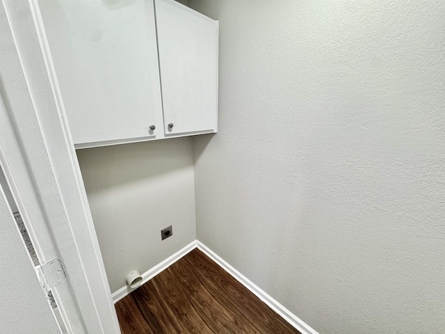 washroom featuring baseboards, cabinet space, hookup for an electric dryer, and dark wood finished floors