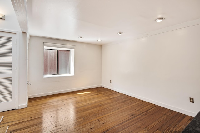 unfurnished room with baseboards and wood-type flooring