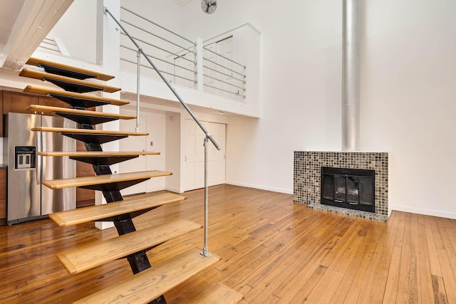 unfurnished living room featuring baseboards, a high ceiling, and hardwood / wood-style flooring