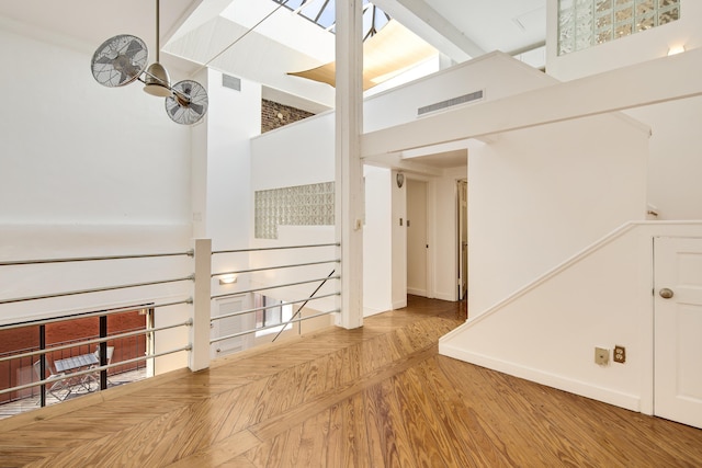 interior space featuring visible vents, a high ceiling, and parquet floors