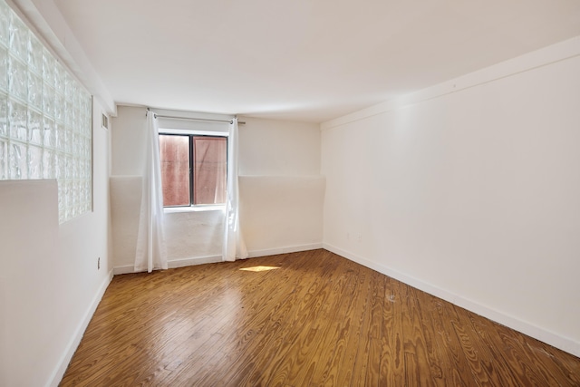 unfurnished room featuring baseboards and wood finished floors