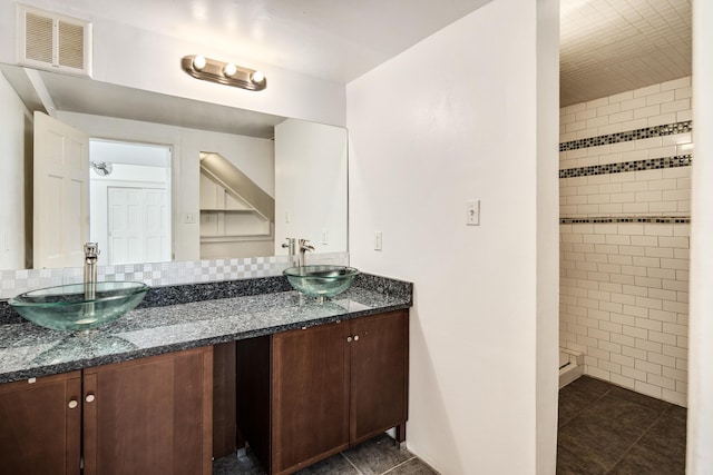 bathroom with double vanity, visible vents, tile patterned flooring, and a sink