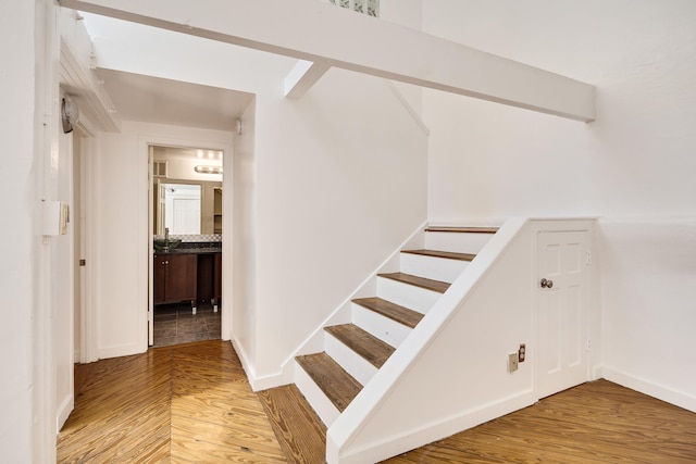 stairs with wood finished floors and baseboards