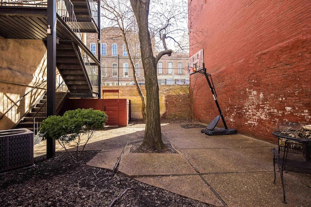 view of patio / terrace with stairway, central AC, and fence