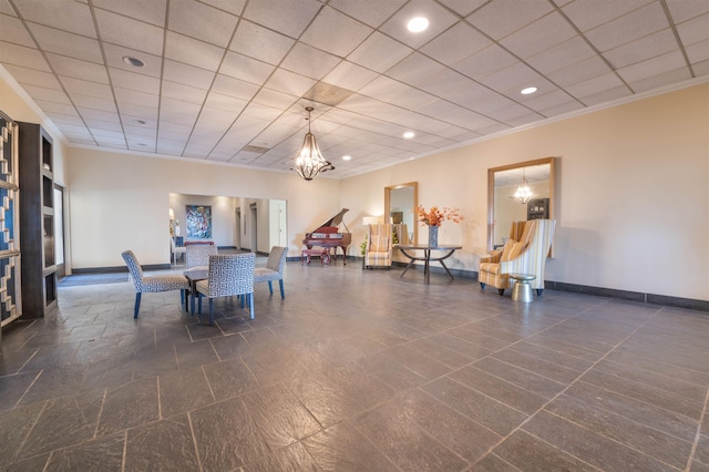 dining area featuring crown molding, a notable chandelier, a paneled ceiling, and baseboards