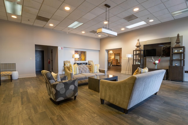 living area with wood finished floors, baseboards, and a towering ceiling