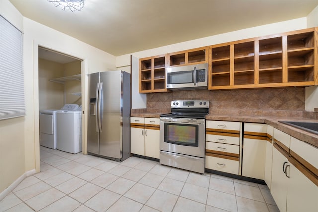 kitchen featuring light tile patterned floors, open shelves, stainless steel appliances, washer and dryer, and backsplash