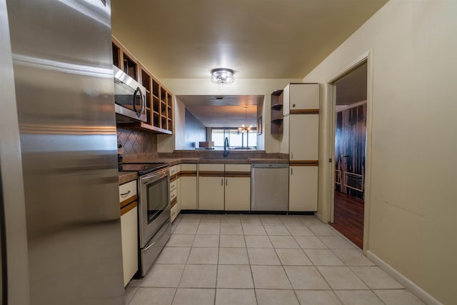 kitchen with open shelves, dark countertops, appliances with stainless steel finishes, and a sink