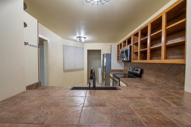 kitchen featuring a sink, open shelves, tasteful backsplash, and appliances with stainless steel finishes