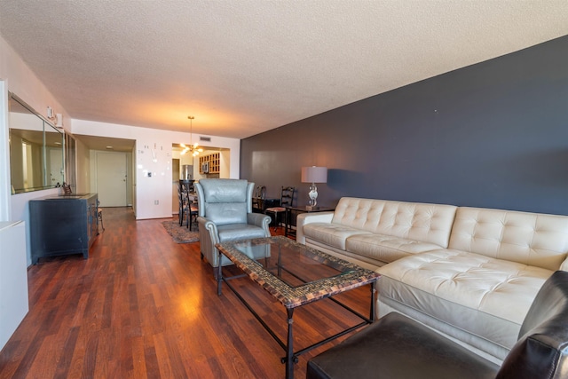 living area with a notable chandelier, a textured ceiling, visible vents, and wood finished floors