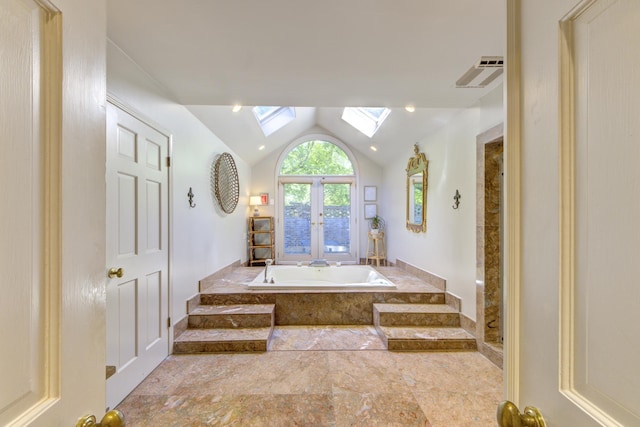 bathroom with visible vents, a garden tub, vaulted ceiling with skylight, french doors, and a shower